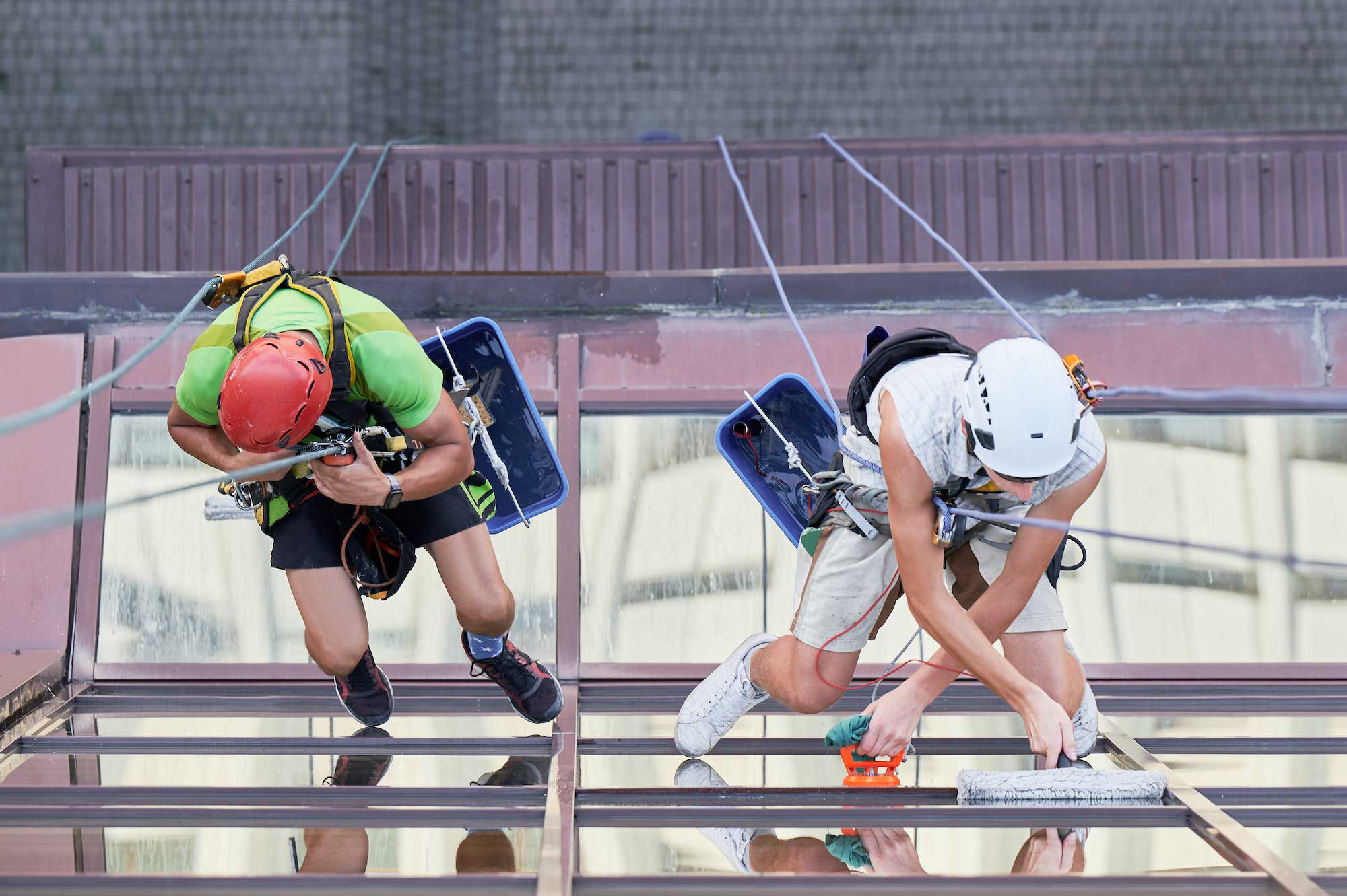 industrial-mountaineering-worker-cleaning-window-outside-building-1-1