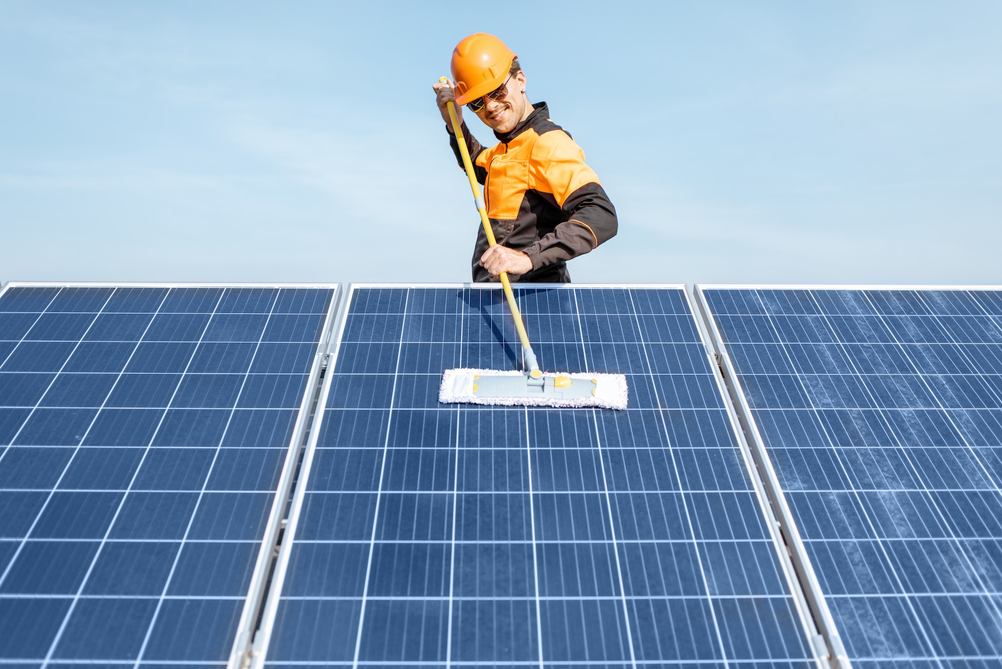 Workman cleaning solar panels